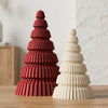 Alberi di Natale decorativi Japandi Trees DEKO in PLA Rosso Scuro e Bianco Avorio: Geometria a gradoni piramidali e scanalature verticali su tavolo in legno di rovere chiaro.