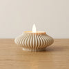 Portacandele Wave DEKO in PLA Bianco Avorio: Texture radiale concentrica con tealight LED su legno di rovere chiaro in luce naturale.