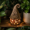 Lanterna Fiorello DEKO accesa: Effetto luce soffusa serale con candela tealight LED e trafori botanici sul davanzale.