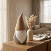 Gnomo Tomte DEKO in ambientazione Japandi Hygge: Su credenza in rovere accanto a vaso ceramico con pampas e luce naturale.