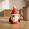 Tomte in Rosso, gnomo di Natale a maglia, su un tavolo in legno chiaro