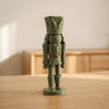 Modern Nutcracker in Verde Scuro, schiaccianoci decorativo sfaccettato, su un tavolo in legno chiaro