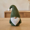 Olav in Verde Scuro, gnomo nordico con la barba, su un tavolo in legno chiaro