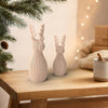 RENNA DEKO Caffelatte in ambiente natalizio hygge: coppia 135 mm e 175 mm tra rami di abete, pigne e luci calde.