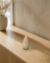 Tomte su una credenza in rovere chiaro: cappello caffelatte, corpo sabbia rigato, barba bianca e naso rosa